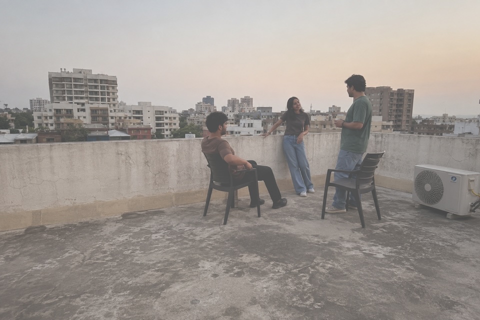 Three friends talking on a residential rooftop terrace.
